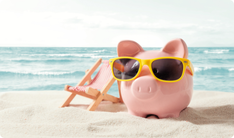 pink piggy back with yellow sunglasses on a beach next to a lounge chair